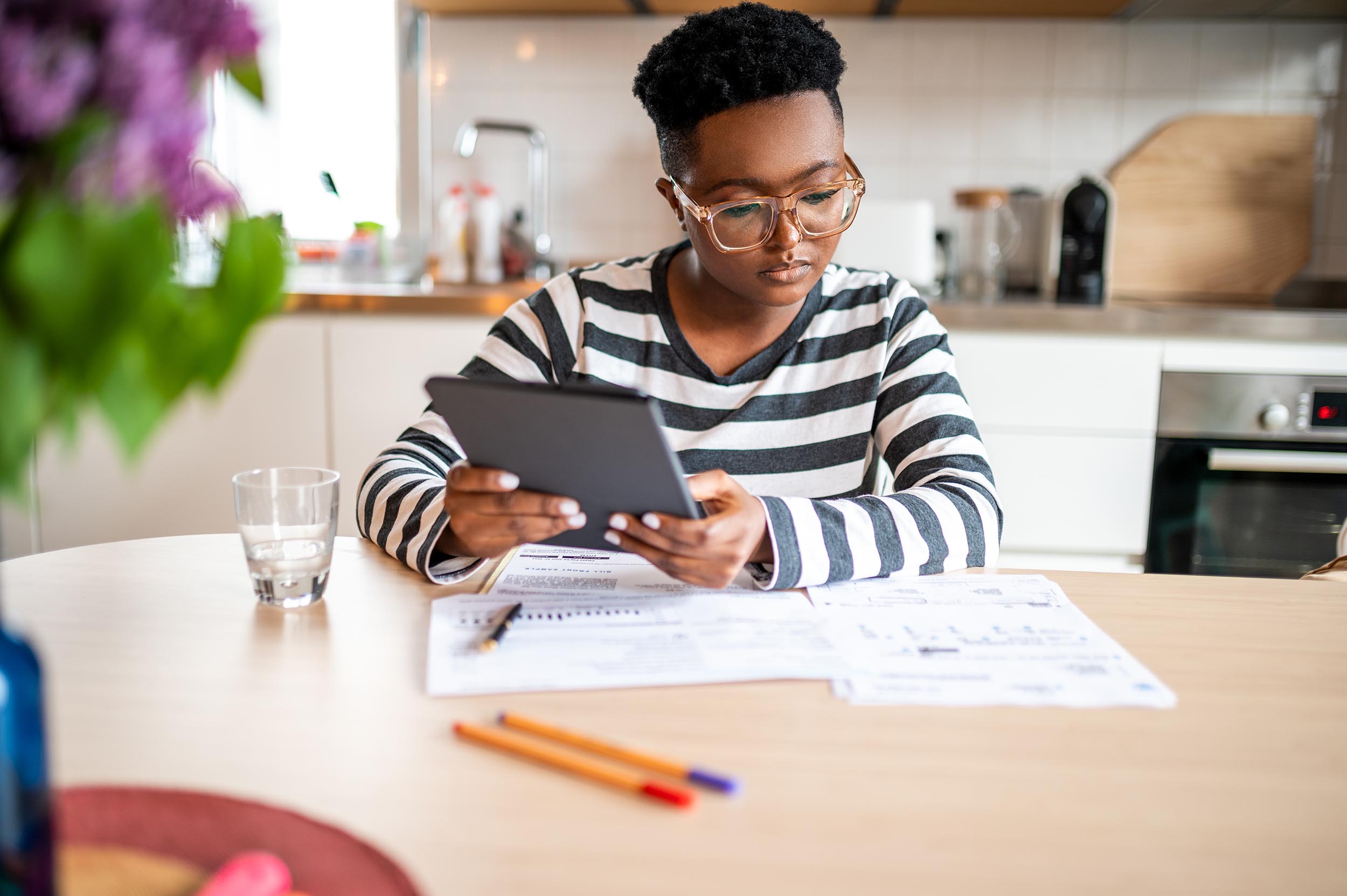 A woman doing taxes sitting in her kitchen